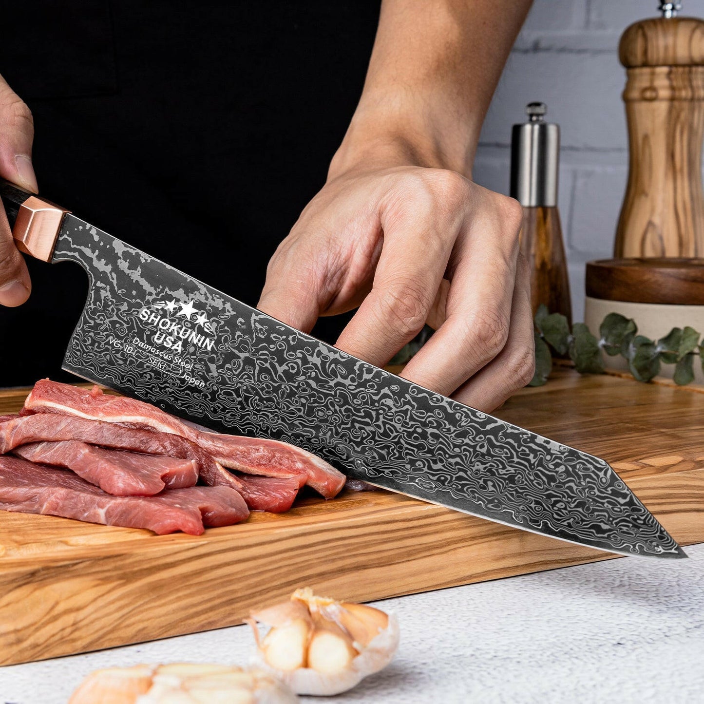 Person using a Shun knife to cut meat on a wooden cutting board with a kitchen setting in the background.