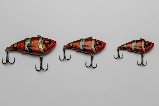 Three fishing lures with a striped pattern on a gray background