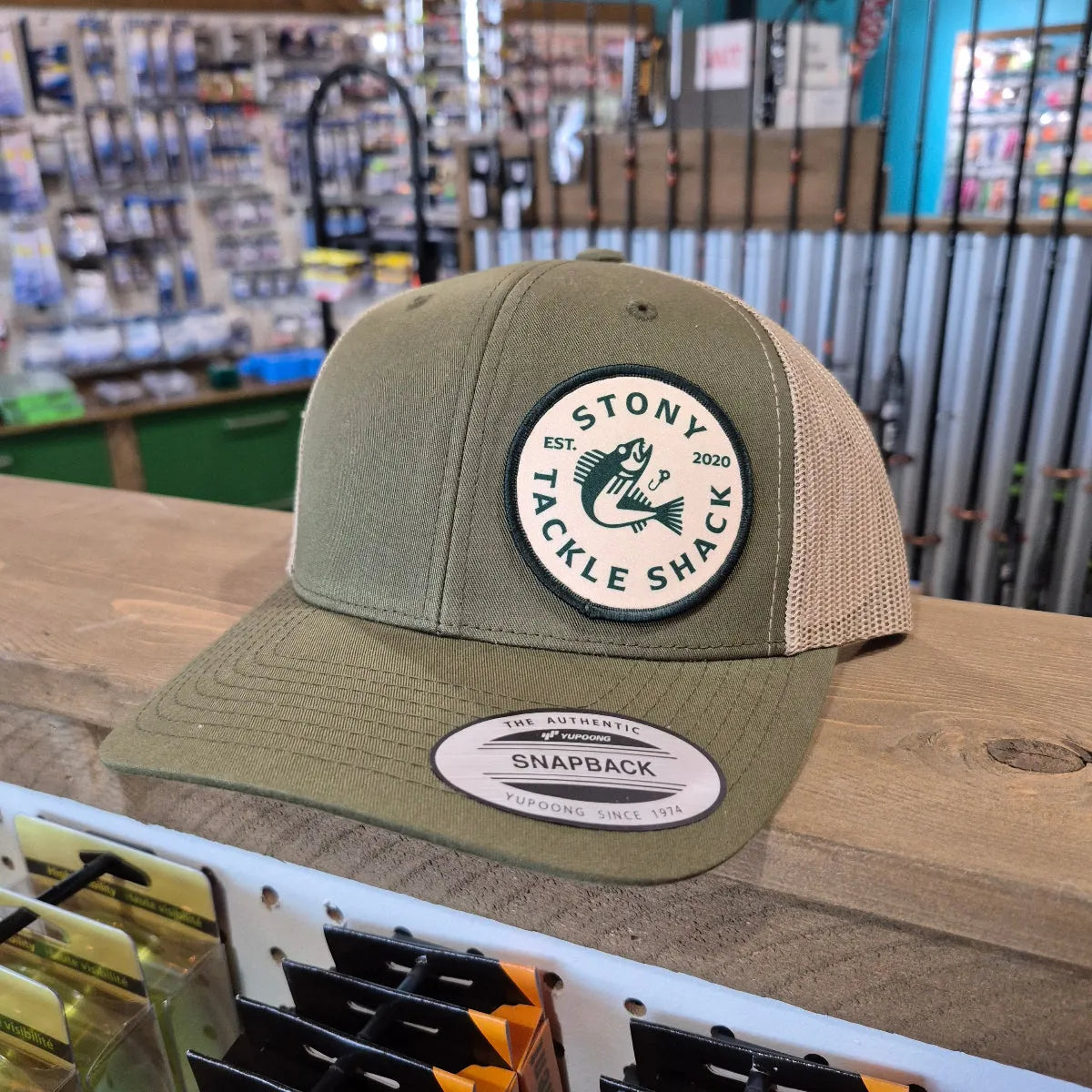 Green cap with a logo on a wooden surface in a store setting