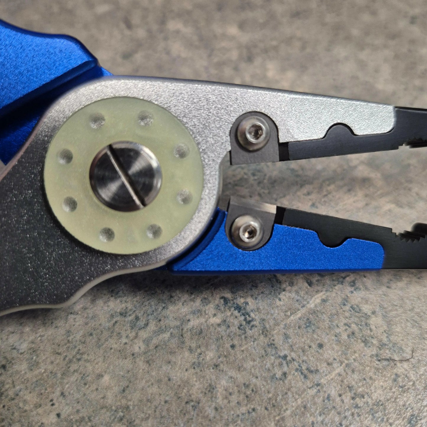 image of fishing pliers showing glow in the dark disc on grey background