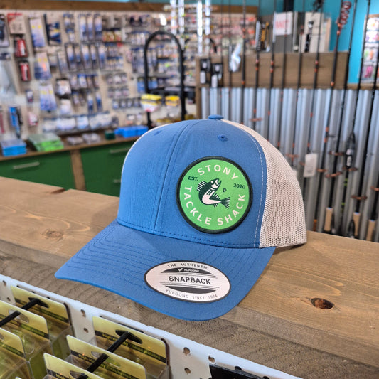 Blue cap with a green logo on a wooden surface in a store setting
