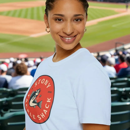 Woman wearing a white t-shirt with a red logo at a baseball stadium