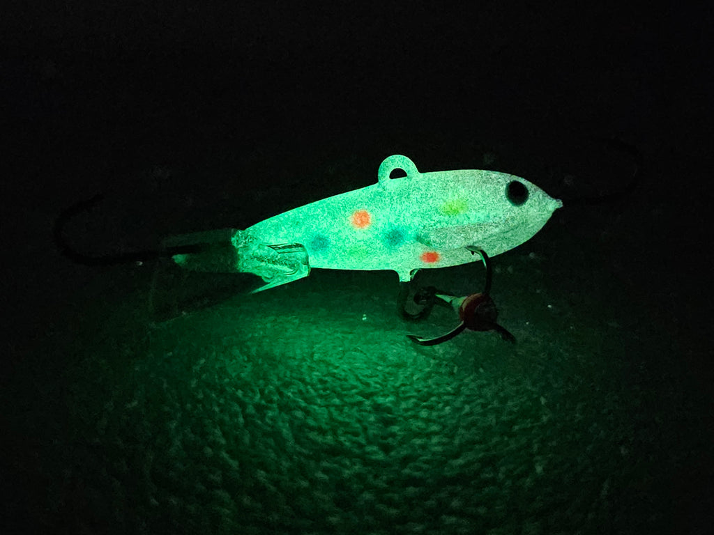 Glowing Atomic Pro Bomberz fishing lure on a dark background