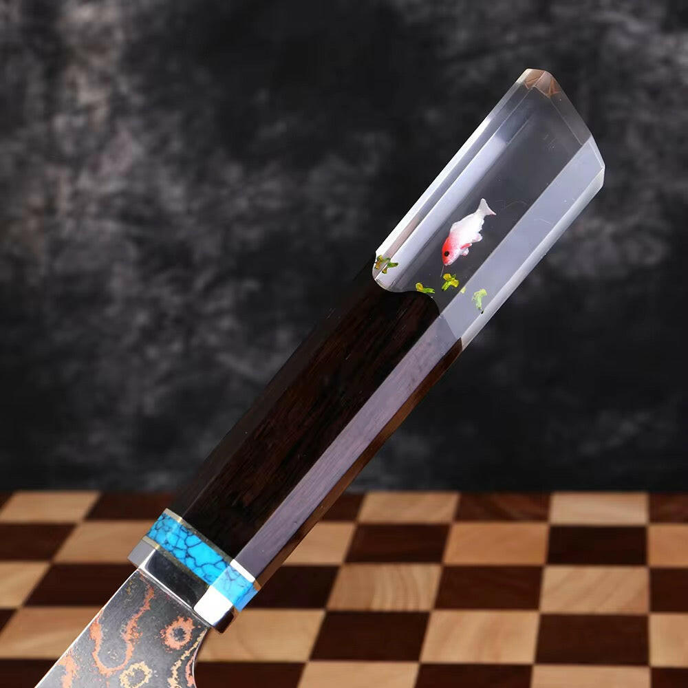 Decorative knife with fish design on a checkered surface
