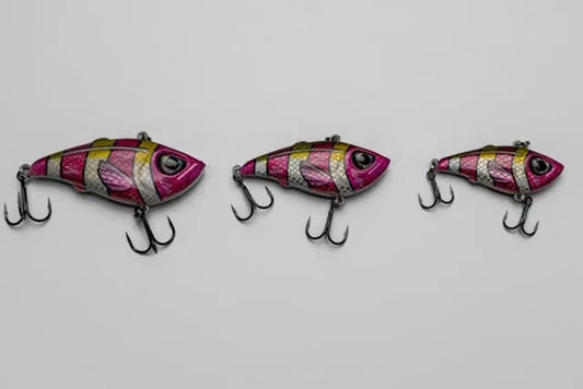Three pink and silver fishing lures on a light gray background