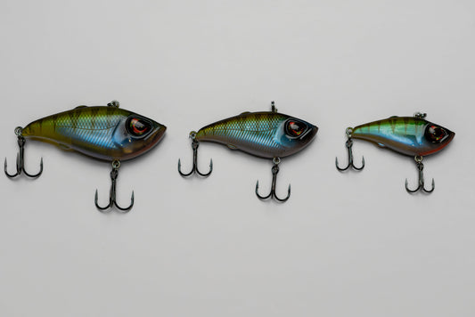 Three fishing lures with treble hooks on a light gray background
