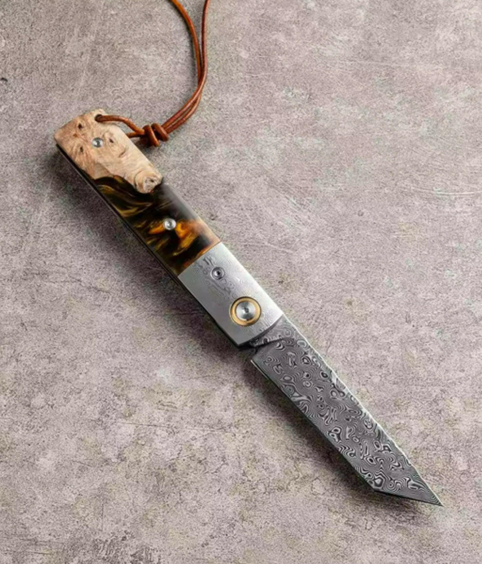 Decorative knife with a wooden handle and leather cord on a gray surface