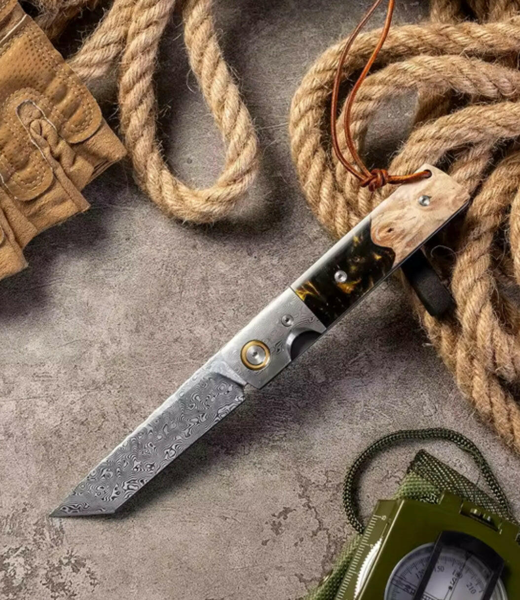 Knife with wooden handle on a concrete surface with rope and compass