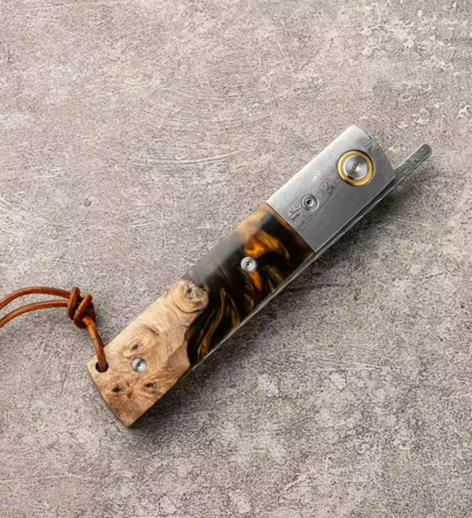 Pocket knife with wooden handle on a textured surface