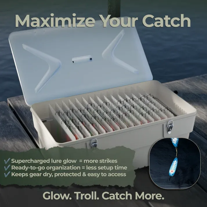 Fishing tackle box with open lid showing organized fishing gear on a dock with water in the background.