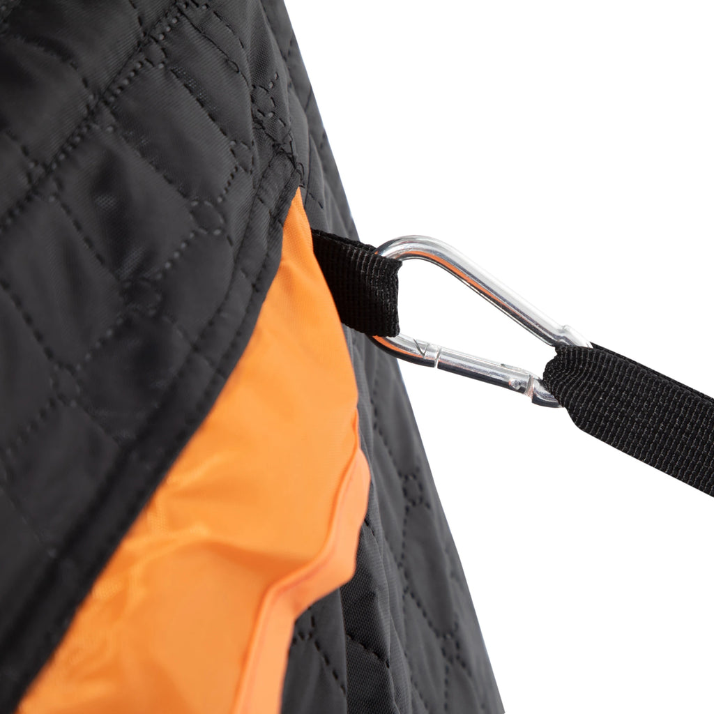 Close-up of a black quilted bag with an orange interior and a carabiner attached.