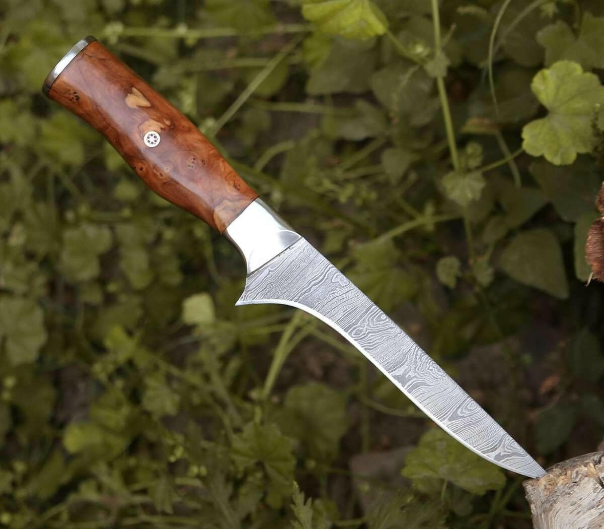 Knife with a wooden handle on a green leafy background