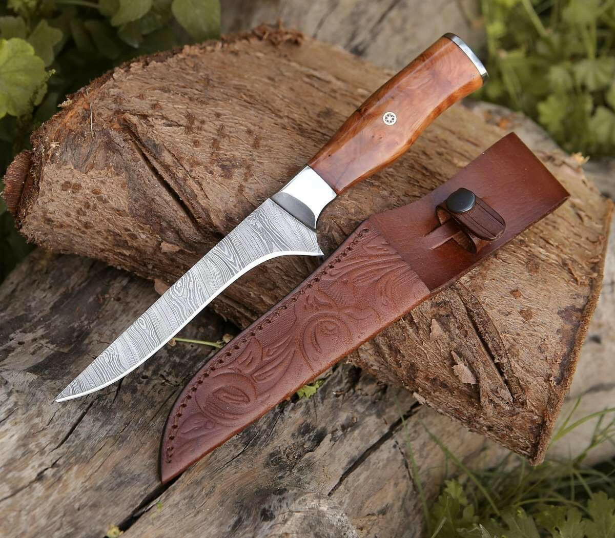 Knife with wooden handle and leather sheath on a wooden log