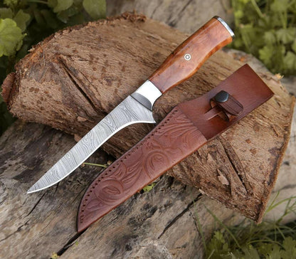 Knife with wooden handle and leather sheath on a wooden log