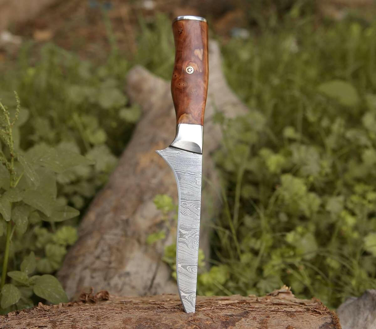 Decorative knife with a wooden handle on a log in a natural setting