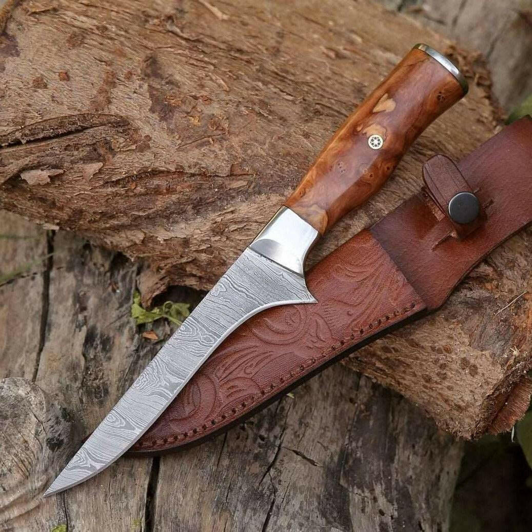 Knife with wooden handle and leather sheath on a wooden surface
