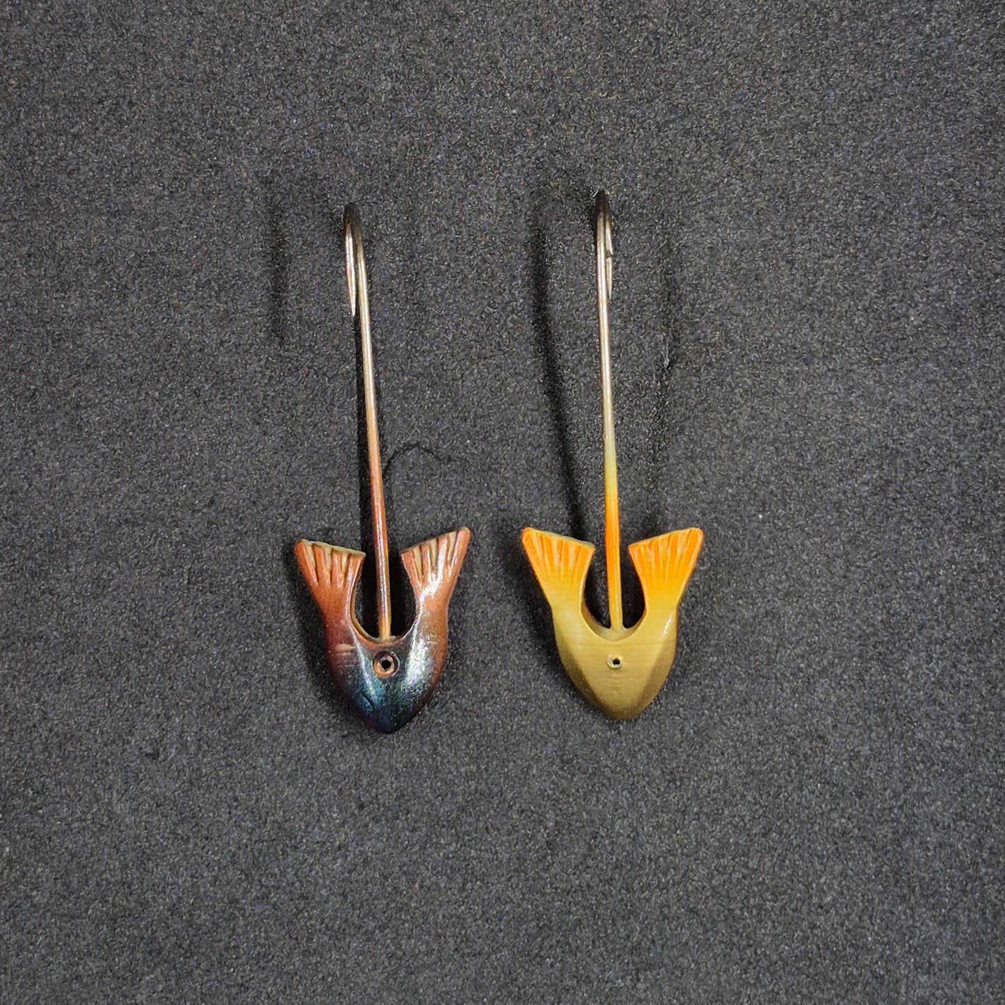 Two fishing lures on a dark textured surface