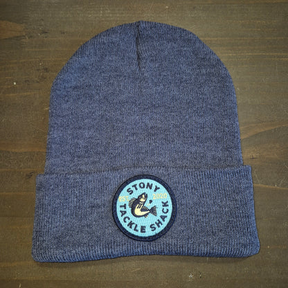 Blue knit beanie with a logo on a wooden surface