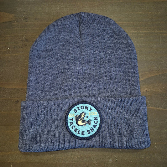 Blue knit beanie with a logo on a wooden surface
