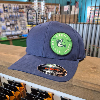 Blue cap with a green logo on a wooden surface in a store setting