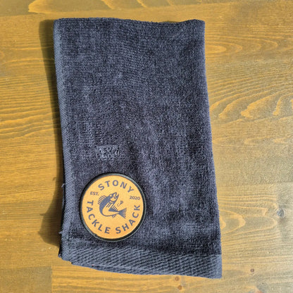 Black hand towel with Yellow Logo on wood background