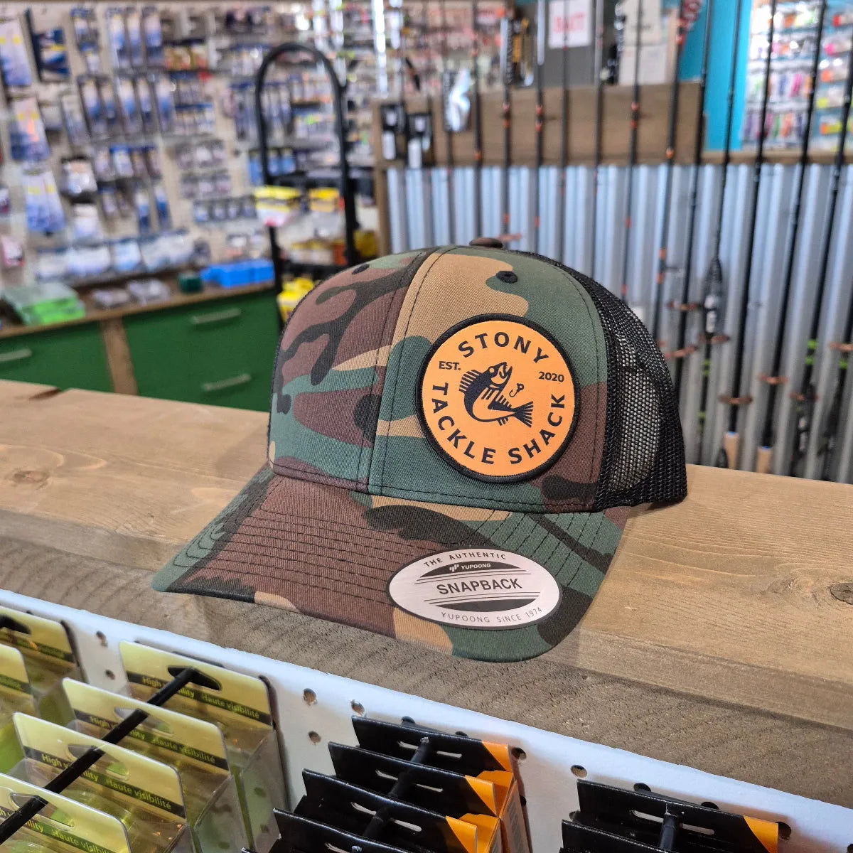 Camouflage cap with a logo on a shelf in a store setting