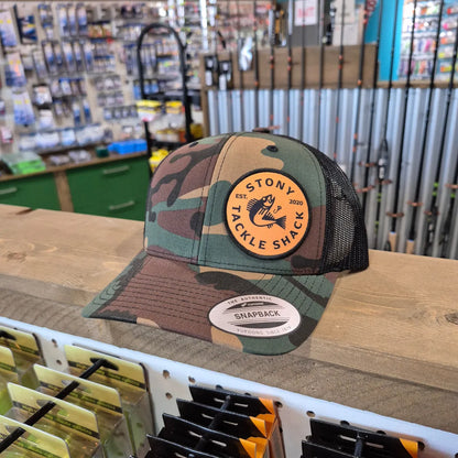 Camouflage cap with a logo on a shelf in a store setting