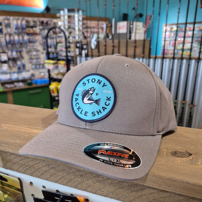 Gray cap with a logo and text on a wooden surface within a store background
