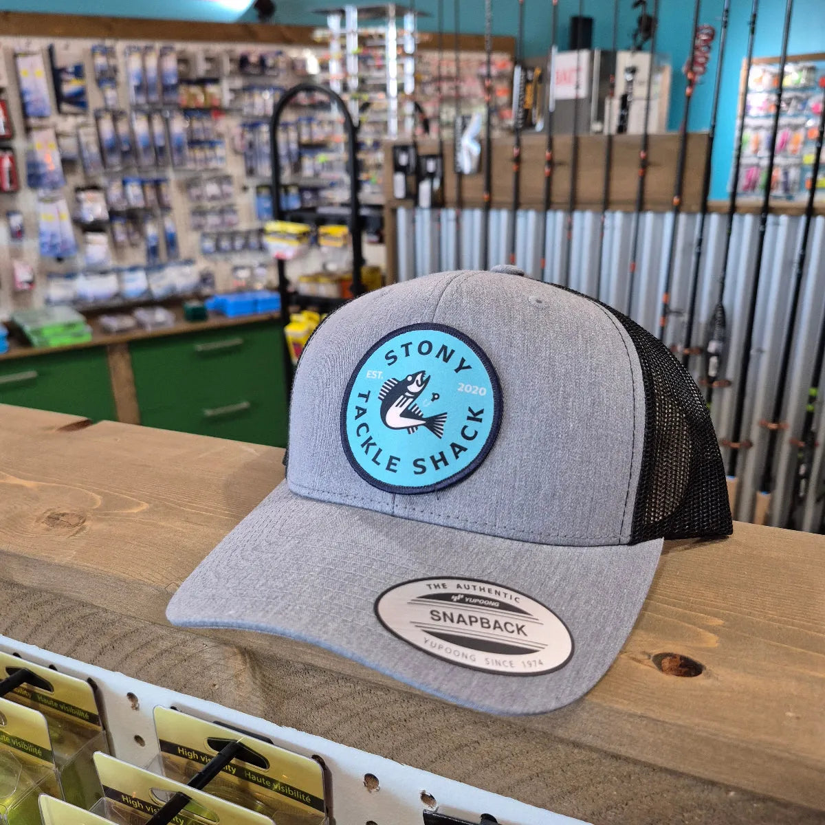 Gray cap with a logo on a wooden surface in a store setting