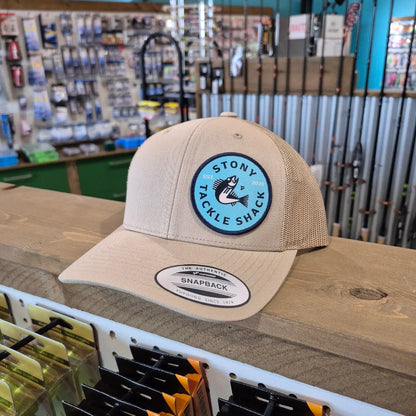 Beige cap with a blue logo on a wooden stand in a store setting