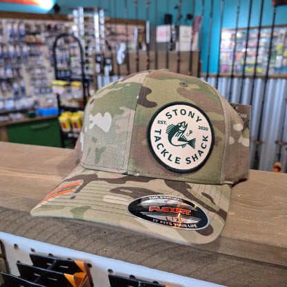 Camouflage cap with a logo on a wooden surface within a store 
