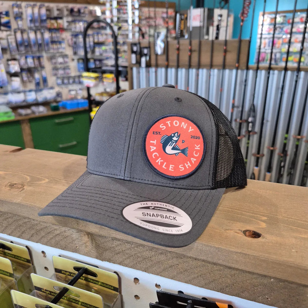 Gray cap with a logo on a wooden surface in a store setting