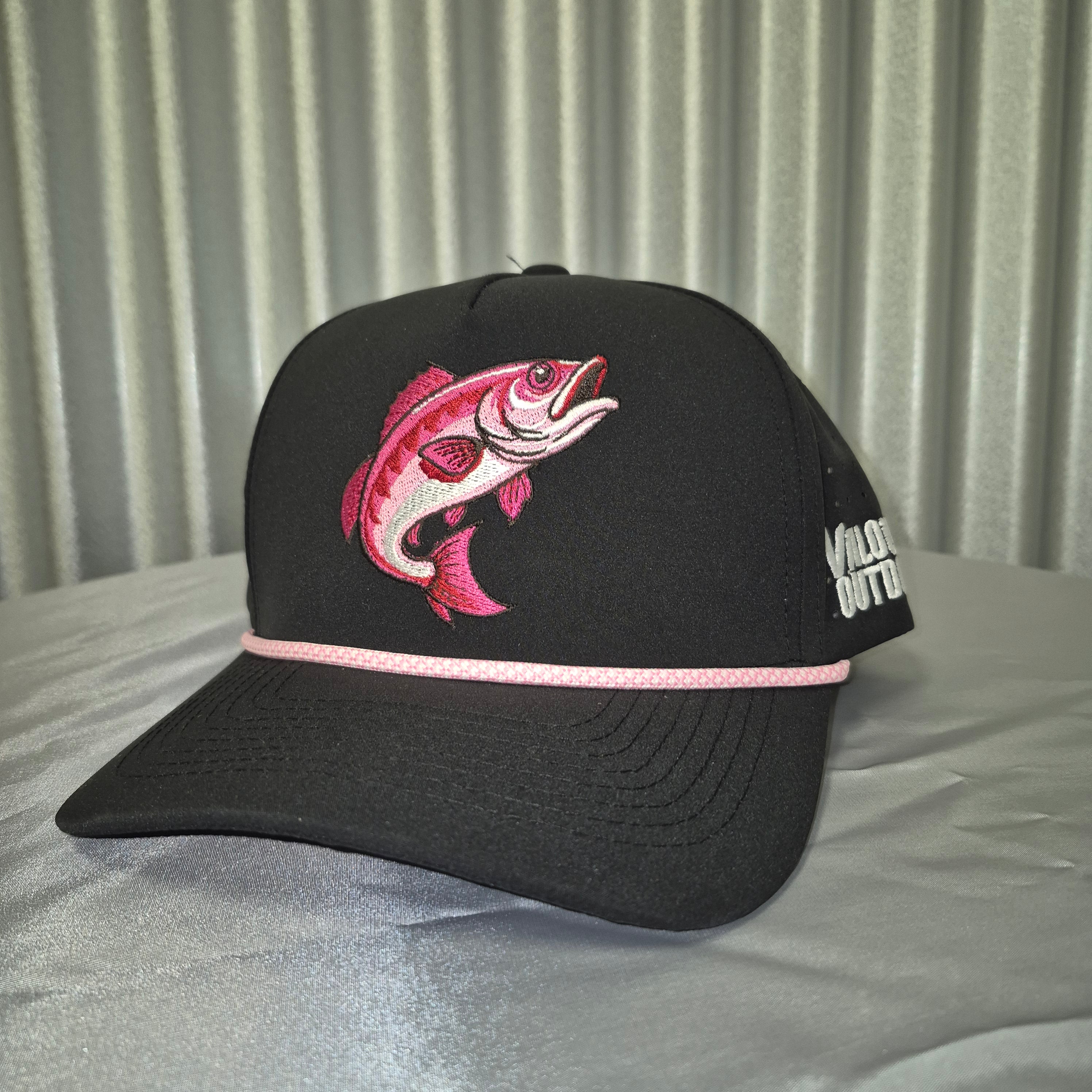 Black cap with pink fish design on a metallic surface