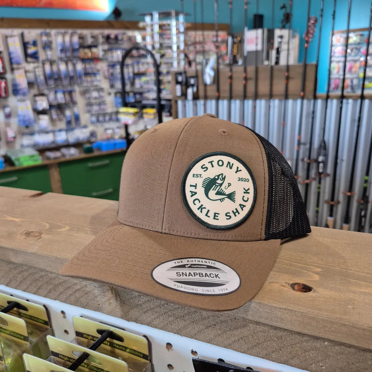 Brown cap with a logo on a wooden surface with a store background