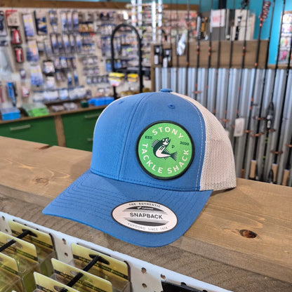 Blue cap with a green logo on a wooden surface in a store setting