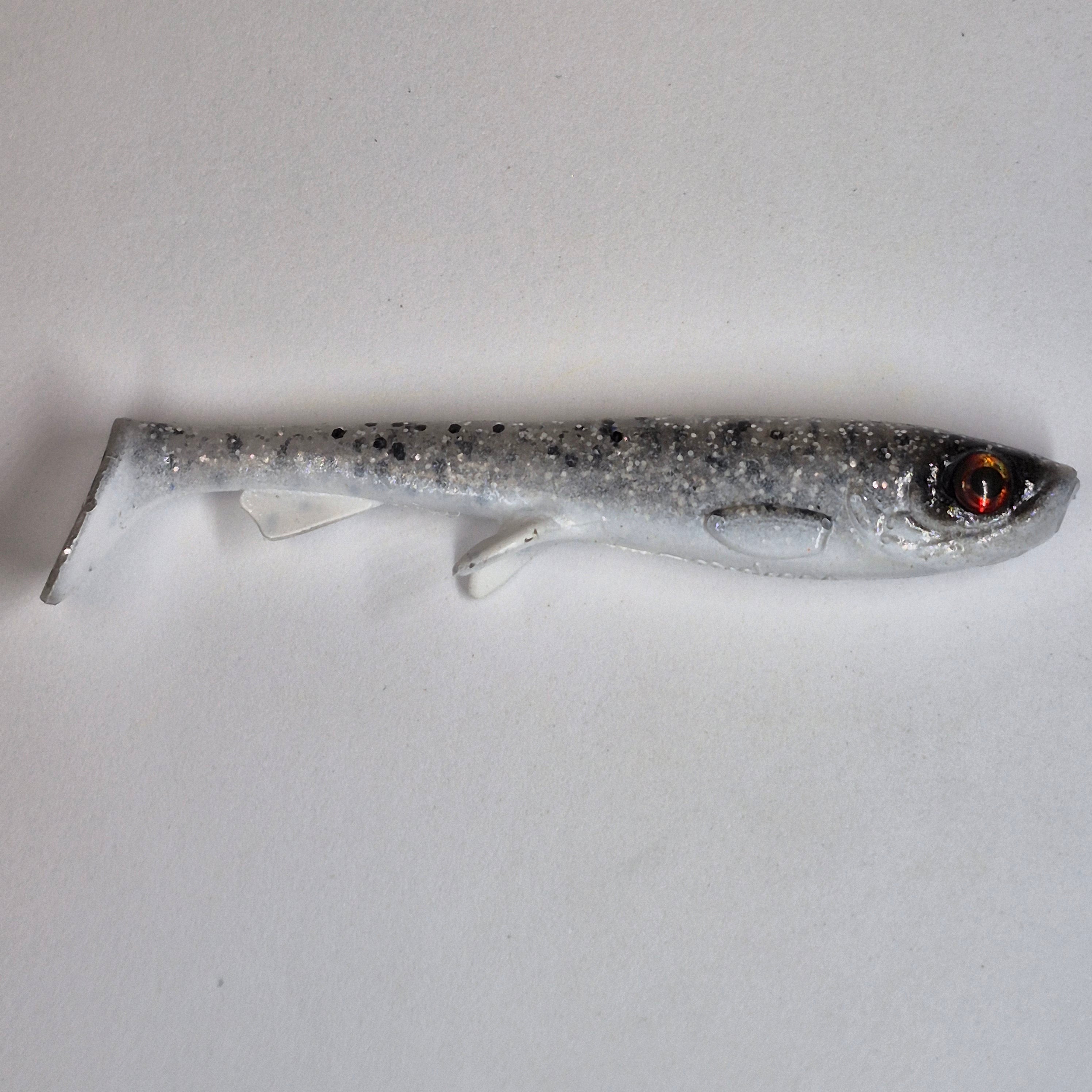 A soft plastic fishing lure shaped like a small fish, featuring a silver and black glitter body with a realistic red and black eye, shown on a plain light gray background.