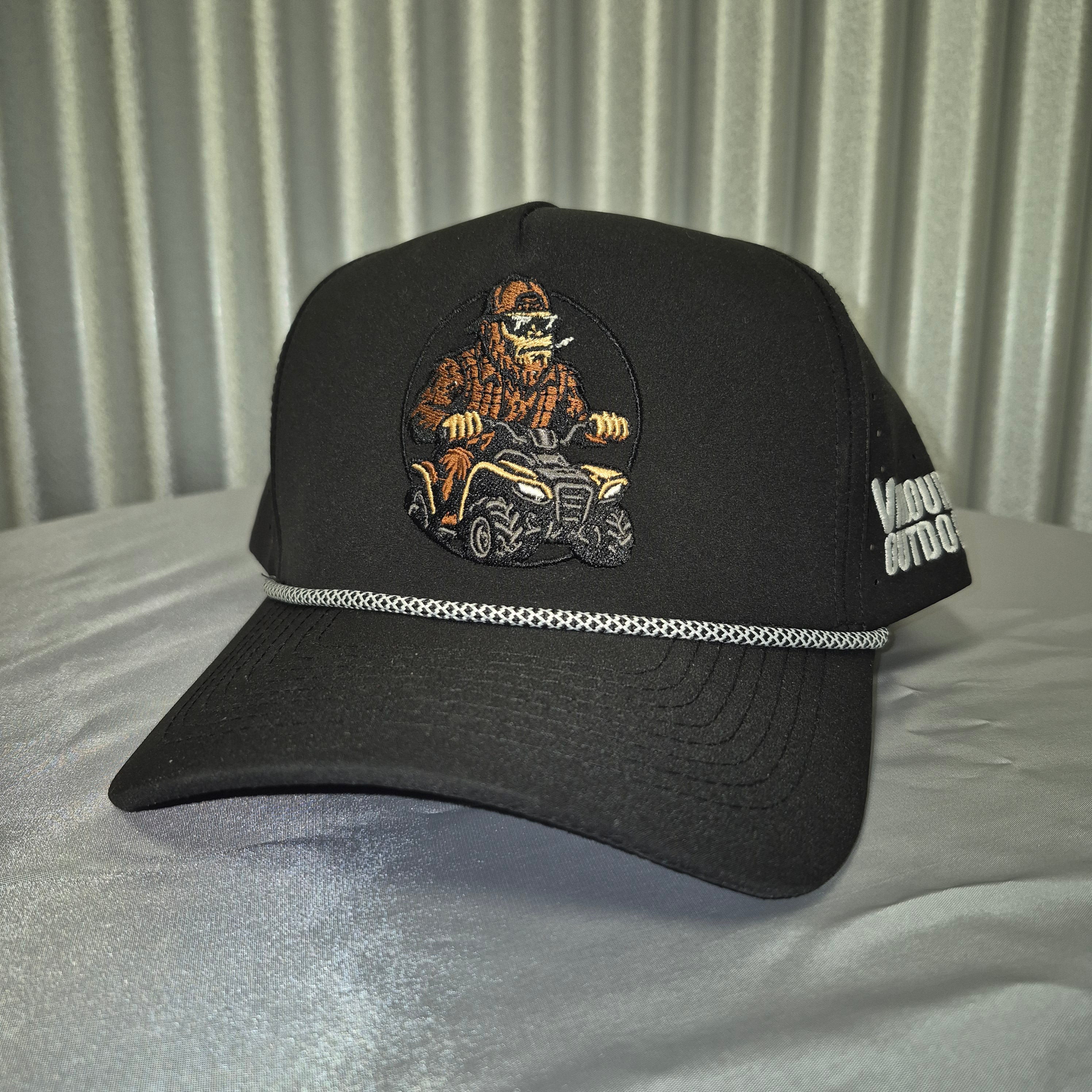Black cap with a sasquatch on an ATV on metallic surface